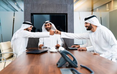 Bir grup Arap işadamı ofiste buluşuyor - Ortadoğulu iş adamları emirati kandora giyiyorlar, Dubai 'de bir toplantı odasında çalışıyorlar.