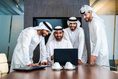 Bir grup Arap işadamı ofiste buluşuyor - Ortadoğulu iş adamları emirati kandora giyiyorlar, Dubai 'de bir toplantı odasında çalışıyorlar.