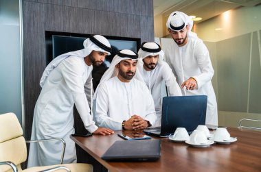 Bir grup Arap işadamı ofiste buluşuyor - Ortadoğulu iş adamları emirati kandora giyiyorlar, Dubai 'de bir toplantı odasında çalışıyorlar.