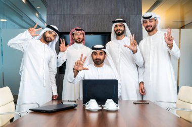 Bir grup Arap işadamı ofiste buluşuyor - Ortadoğulu iş adamları emirati kandora giyiyorlar, Dubai 'de bir toplantı odasında çalışıyorlar.