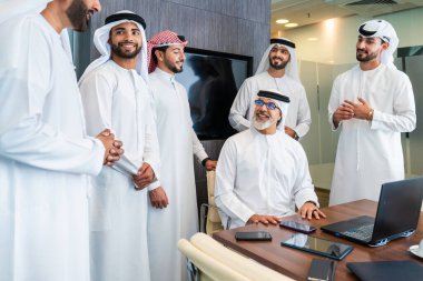 Bir grup Arap işadamı ofiste buluşuyor - Ortadoğulu iş adamları emirati kandora giyiyorlar, Dubai 'de bir toplantı odasında çalışıyorlar.