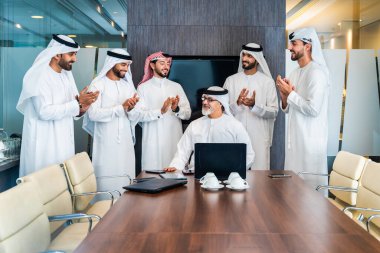 Bir grup Arap işadamı ofiste buluşuyor - Ortadoğulu iş adamları emirati kandora giyiyorlar, Dubai 'de bir toplantı odasında çalışıyorlar.