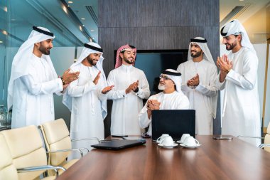 Bir grup Arap işadamı ofiste buluşuyor - Ortadoğulu iş adamları emirati kandora giyiyorlar, Dubai 'de bir toplantı odasında çalışıyorlar.