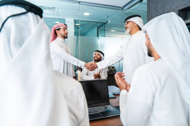 Bir grup Arap işadamı ofiste buluşuyor - Ortadoğulu iş adamları emirati kandora giyiyorlar, Dubai 'de bir toplantı odasında çalışıyorlar.