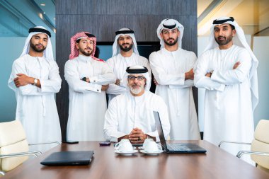 Bir grup Arap işadamı ofiste buluşuyor - Ortadoğulu iş adamları emirati kandora giyiyorlar, Dubai 'de bir toplantı odasında çalışıyorlar.