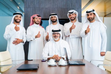 Bir grup Arap işadamı ofiste buluşuyor - Ortadoğulu iş adamları emirati kandora giyiyorlar, Dubai 'de bir toplantı odasında çalışıyorlar.