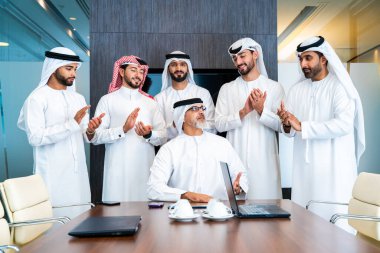 Bir grup Arap işadamı ofiste buluşuyor - Ortadoğulu iş adamları emirati kandora giyiyorlar, Dubai 'de bir toplantı odasında çalışıyorlar.