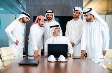 Bir grup Arap işadamı ofiste buluşuyor - Ortadoğulu iş adamları emirati kandora giyiyorlar, Dubai 'de bir toplantı odasında çalışıyorlar.