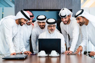 Bir grup Arap işadamı ofiste buluşuyor - Ortadoğulu iş adamları emirati kandora giyiyorlar, Dubai 'de bir toplantı odasında çalışıyorlar.