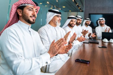 Bir grup Arap işadamı ofiste buluşuyor - Ortadoğulu iş adamları emirati kandora giyiyorlar, Dubai 'de bir toplantı odasında çalışıyorlar.