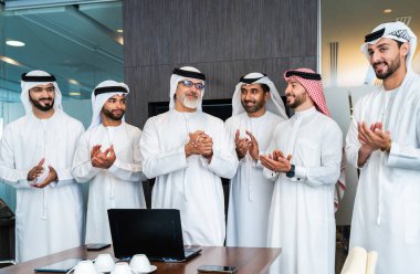 Bir grup Arap işadamı ofiste buluşuyor - Ortadoğulu iş adamları emirati kandora giyiyorlar, Dubai 'de bir toplantı odasında çalışıyorlar.