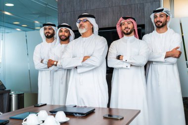 Bir grup Arap işadamı ofiste buluşuyor - Ortadoğulu iş adamları emirati kandora giyiyorlar, Dubai 'de bir toplantı odasında çalışıyorlar.