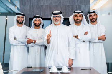Bir grup Arap işadamı ofiste buluşuyor - Ortadoğulu iş adamları emirati kandora giyiyorlar, Dubai 'de bir toplantı odasında çalışıyorlar.