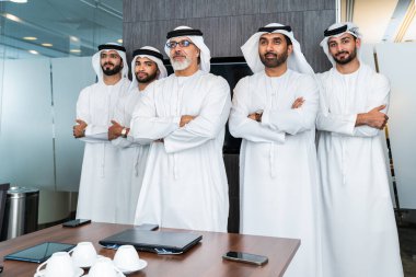 Bir grup Arap işadamı ofiste buluşuyor - Ortadoğulu iş adamları emirati kandora giyiyorlar, Dubai 'de bir toplantı odasında çalışıyorlar.