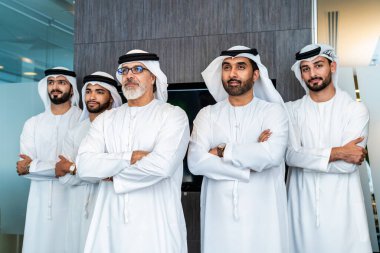 Bir grup Arap işadamı ofiste buluşuyor - Ortadoğulu iş adamları emirati kandora giyiyorlar, Dubai 'de bir toplantı odasında çalışıyorlar.