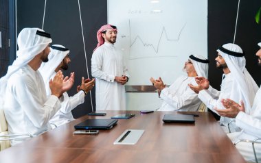 Bir grup Arap işadamı ofiste buluşuyor - Ortadoğulu iş adamları emirati kandora giyiyorlar, Dubai 'de bir toplantı odasında çalışıyorlar.