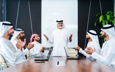 Bir grup Arap işadamı ofiste buluşuyor - Ortadoğulu iş adamları emirati kandora giyiyorlar, Dubai 'de bir toplantı odasında çalışıyorlar.