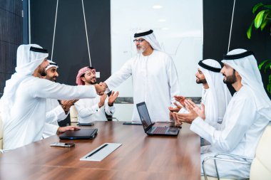 Bir grup Arap işadamı ofiste buluşuyor - Ortadoğulu iş adamları emirati kandora giyiyorlar, Dubai 'de bir toplantı odasında çalışıyorlar.