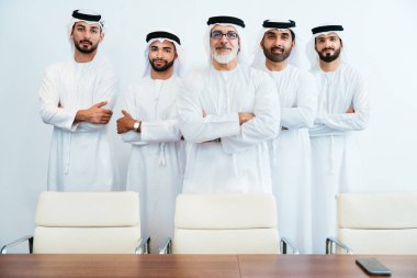 Bir grup Arap işadamı ofiste buluşuyor - Ortadoğulu iş adamları emirati kandora giyiyorlar, Dubai 'de bir toplantı odasında çalışıyorlar.
