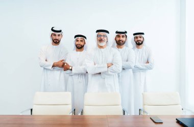 Bir grup Arap işadamı ofiste buluşuyor - Ortadoğulu iş adamları emirati kandora giyiyorlar, Dubai 'de bir toplantı odasında çalışıyorlar.