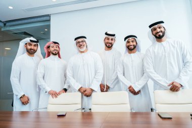Bir grup Arap işadamı ofiste buluşuyor - Ortadoğulu iş adamları emirati kandora giyiyorlar, Dubai 'de bir toplantı odasında çalışıyorlar.