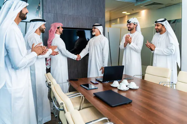 Bir grup Arap işadamı ofiste buluşuyor - Ortadoğulu iş adamları emirati kandora giyiyorlar, Dubai 'de bir toplantı odasında çalışıyorlar.