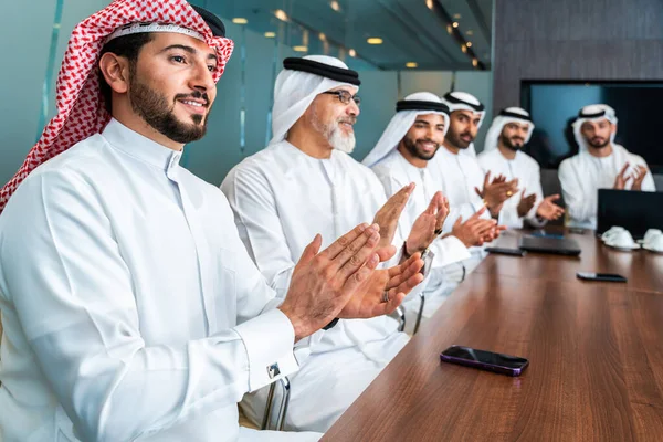 Bir grup Arap işadamı ofiste buluşuyor - Ortadoğulu iş adamları emirati kandora giyiyorlar, Dubai 'de bir toplantı odasında çalışıyorlar.