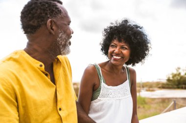 Güzel, olgun, siyahi çift deniz kenarında flört ediyor evli, orta yaşlı çift dışarıda eğleniyor, ilişki, yaşam tarzı ve yaşam kalitesi kavramları.
