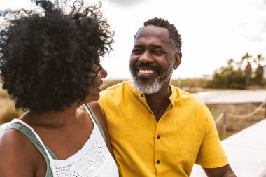 Güzel, olgun, siyahi çift deniz kenarında flört ediyor evli, orta yaşlı çift dışarıda eğleniyor, ilişki, yaşam tarzı ve yaşam kalitesi kavramları.