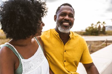 Güzel, olgun, siyahi çift deniz kenarında flört ediyor evli, orta yaşlı çift dışarıda eğleniyor, ilişki, yaşam tarzı ve yaşam kalitesi kavramları.