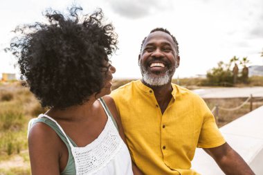 Güzel, olgun, siyahi çift deniz kenarında flört ediyor evli, orta yaşlı çift dışarıda eğleniyor, ilişki, yaşam tarzı ve yaşam kalitesi kavramları.