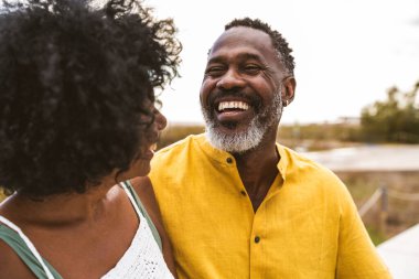 Güzel, olgun, siyahi çift deniz kenarında flört ediyor evli, orta yaşlı çift dışarıda eğleniyor, ilişki, yaşam tarzı ve yaşam kalitesi kavramları.