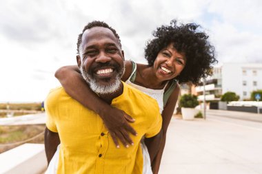 Güzel, olgun, siyahi çift deniz kenarında flört ediyor evli, orta yaşlı çift dışarıda eğleniyor, ilişki, yaşam tarzı ve yaşam kalitesi kavramları.