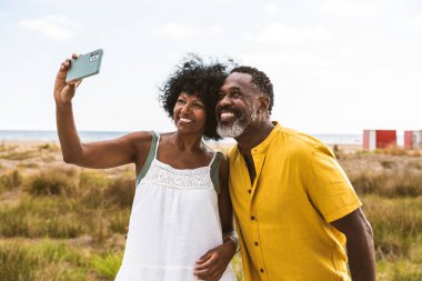Güzel, olgun, siyahi çift deniz kenarında flört ediyor evli, orta yaşlı çift dışarıda eğleniyor, ilişki, yaşam tarzı ve yaşam kalitesi kavramları.