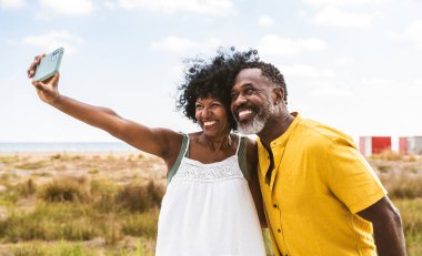Güzel, olgun, siyahi çift deniz kenarında flört ediyor evli, orta yaşlı çift dışarıda eğleniyor, ilişki, yaşam tarzı ve yaşam kalitesi kavramları.