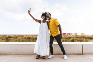 Güzel, olgun, siyahi çift deniz kenarında flört ediyor evli, orta yaşlı çift dışarıda eğleniyor, ilişki, yaşam tarzı ve yaşam kalitesi kavramları.