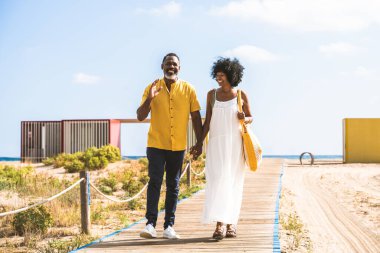 Güzel, olgun, siyahi çift deniz kenarında flört ediyor evli, orta yaşlı çift dışarıda eğleniyor, ilişki, yaşam tarzı ve yaşam kalitesi kavramları.