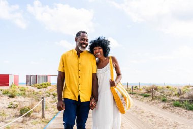 Güzel, olgun, siyahi çift deniz kenarında flört ediyor evli, orta yaşlı çift dışarıda eğleniyor, ilişki, yaşam tarzı ve yaşam kalitesi kavramları.