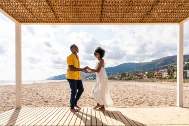 Güzel, olgun, siyahi çift deniz kenarında flört ediyor evli, orta yaşlı çift dışarıda eğleniyor, ilişki, yaşam tarzı ve yaşam kalitesi kavramları.