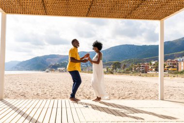 Güzel, olgun, siyahi çift deniz kenarında flört ediyor evli, orta yaşlı çift dışarıda eğleniyor, ilişki, yaşam tarzı ve yaşam kalitesi kavramları.