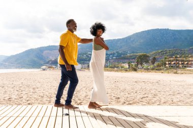 Güzel, olgun, siyahi çift deniz kenarında flört ediyor evli, orta yaşlı çift dışarıda eğleniyor, ilişki, yaşam tarzı ve yaşam kalitesi kavramları.