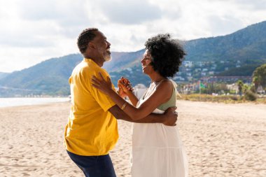 Güzel, olgun, siyahi çift deniz kenarında flört ediyor evli, orta yaşlı çift dışarıda eğleniyor, ilişki, yaşam tarzı ve yaşam kalitesi kavramları.