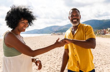 Güzel, olgun, siyahi çift deniz kenarında flört ediyor evli, orta yaşlı çift dışarıda eğleniyor, ilişki, yaşam tarzı ve yaşam kalitesi kavramları.