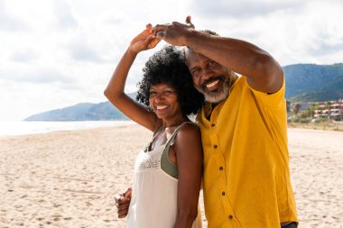 Güzel, olgun, siyahi çift deniz kenarında flört ediyor evli, orta yaşlı çift dışarıda eğleniyor, ilişki, yaşam tarzı ve yaşam kalitesi kavramları.