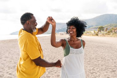 Güzel, olgun, siyahi çift deniz kenarında flört ediyor evli, orta yaşlı çift dışarıda eğleniyor, ilişki, yaşam tarzı ve yaşam kalitesi kavramları.