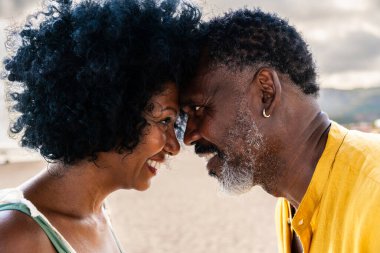 Güzel, olgun, siyahi çift deniz kenarında flört ediyor evli, orta yaşlı çift dışarıda eğleniyor, ilişki, yaşam tarzı ve yaşam kalitesi kavramları.