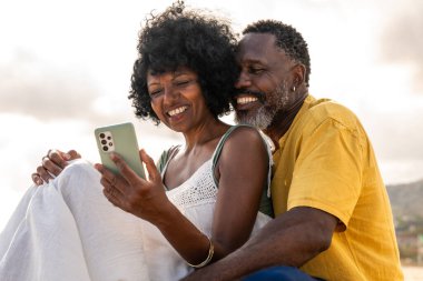 Güzel, olgun, siyahi çift deniz kenarında flört ediyor evli, orta yaşlı çift dışarıda eğleniyor, ilişki, yaşam tarzı ve yaşam kalitesi kavramları.