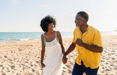 Güzel, olgun, siyahi çift deniz kenarında flört ediyor evli, orta yaşlı çift dışarıda eğleniyor, ilişki, yaşam tarzı ve yaşam kalitesi kavramları.