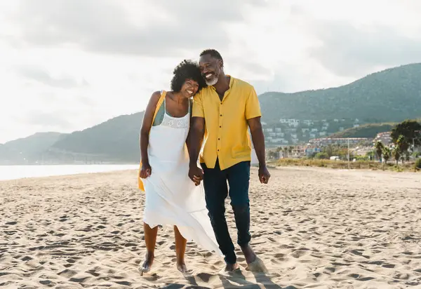 Güzel, olgun, siyahi çift deniz kenarında flört ediyor evli, orta yaşlı çift dışarıda eğleniyor, ilişki, yaşam tarzı ve yaşam kalitesi kavramları.