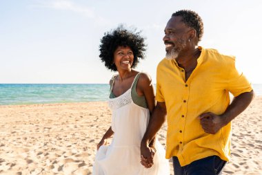 Güzel, olgun, siyahi çift deniz kenarında flört ediyor evli, orta yaşlı çift dışarıda eğleniyor, ilişki, yaşam tarzı ve yaşam kalitesi kavramları.